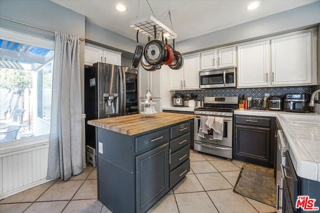 kitchen featuring appliances with stainless steel finishes, sink, decorative backsplash, and white cabinets