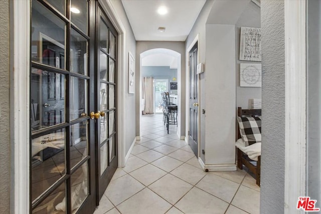 hall featuring light tile patterned floors