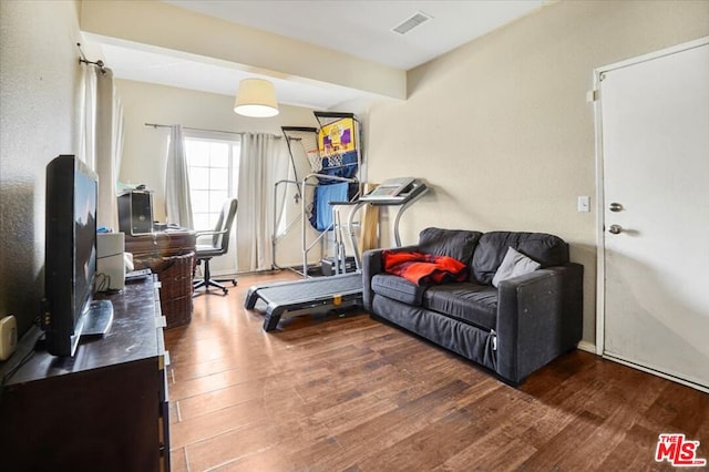 living room with beamed ceiling and dark wood-type flooring