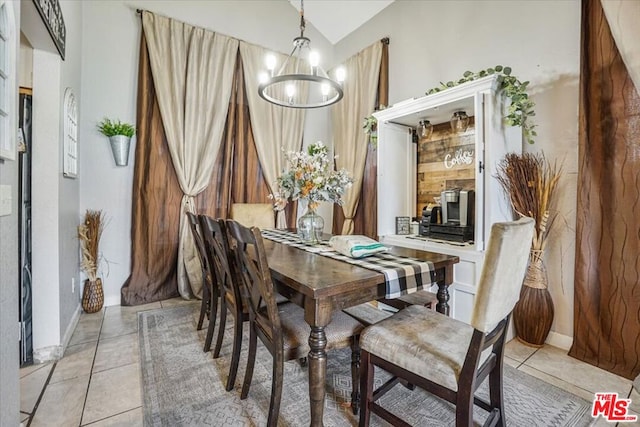 tiled dining space with vaulted ceiling and a notable chandelier