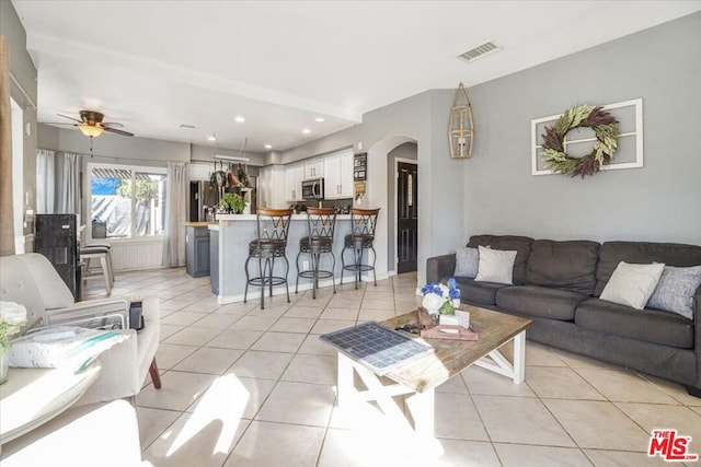 tiled living room with ceiling fan