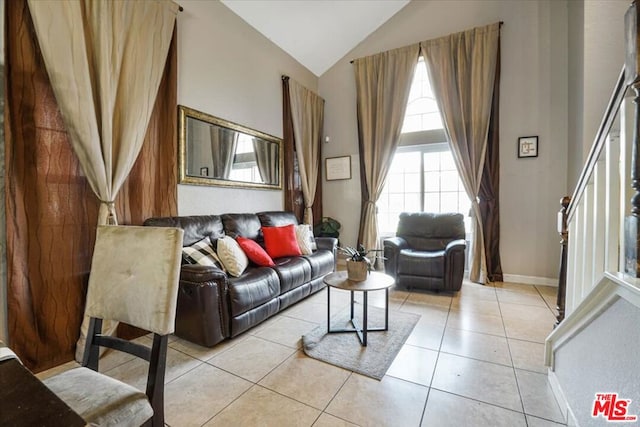 living room featuring high vaulted ceiling and light tile patterned flooring