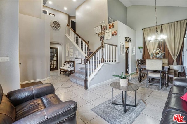 tiled living room with high vaulted ceiling and a notable chandelier