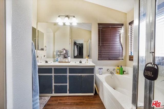 bathroom with vaulted ceiling, vanity, shower with separate bathtub, and hardwood / wood-style floors