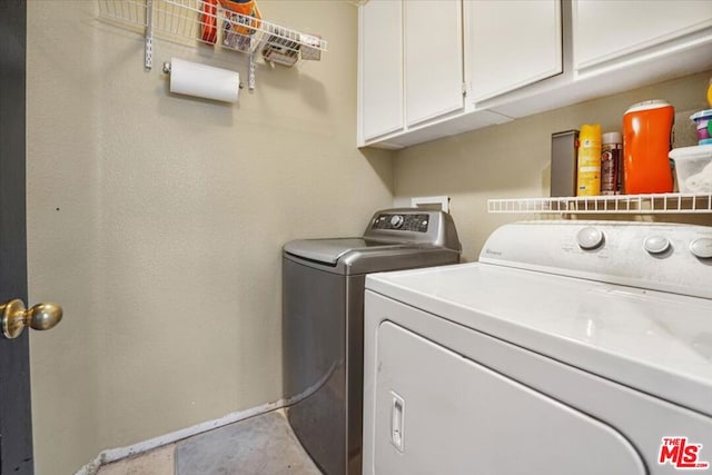 washroom featuring separate washer and dryer and cabinets