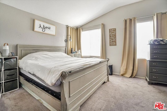 bedroom featuring multiple windows, lofted ceiling, and carpet