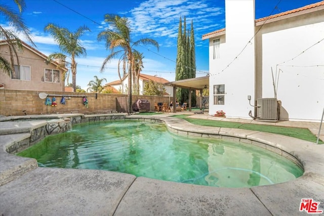 view of swimming pool featuring cooling unit, pool water feature, and a patio area