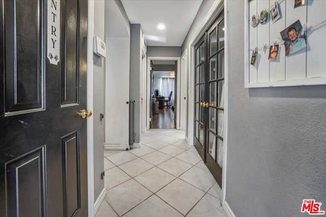 hallway featuring light tile patterned floors and french doors