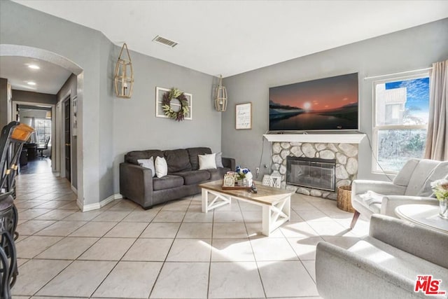 tiled living room featuring a fireplace