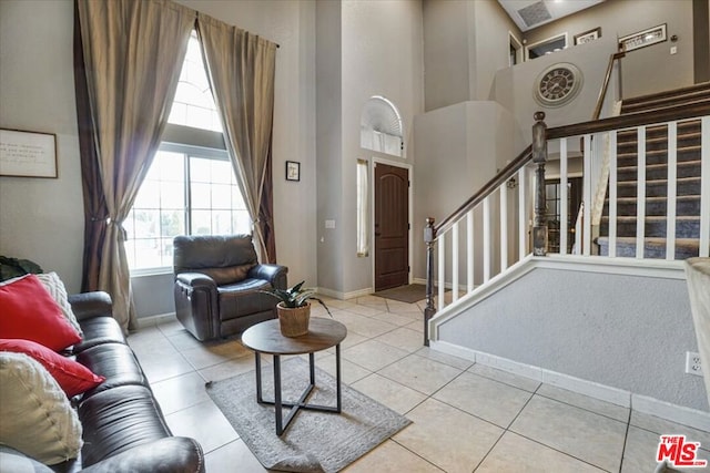 tiled living room featuring a high ceiling