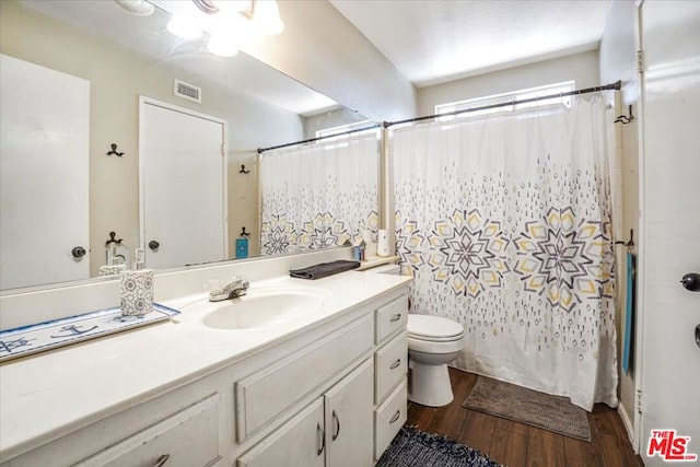 bathroom with wood-type flooring, vanity, and toilet