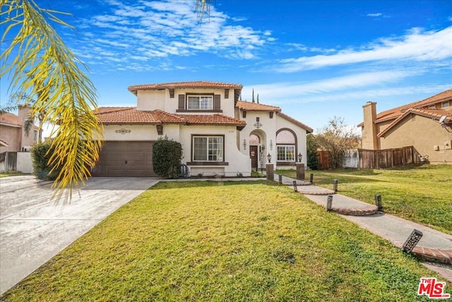 mediterranean / spanish-style house featuring a garage and a front yard