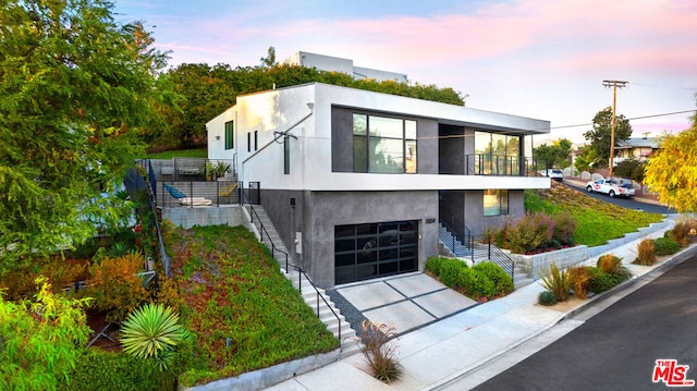 contemporary home featuring a balcony and a garage