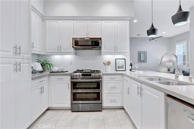 kitchen with white cabinets, stainless steel appliances, and decorative light fixtures