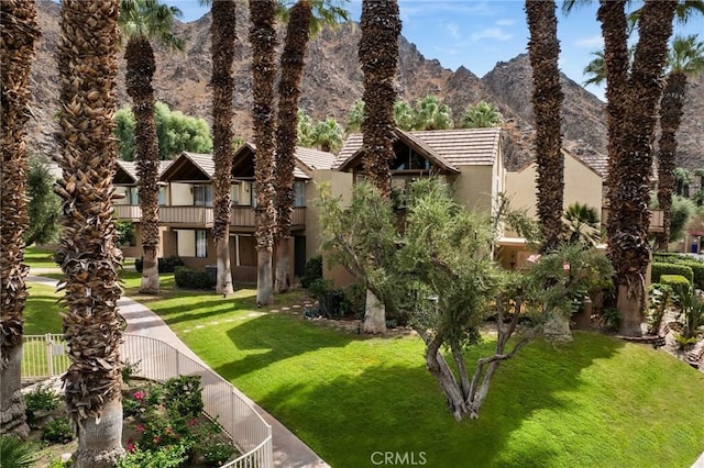 view of front of house with a mountain view and a front lawn