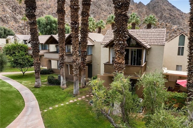 view of front facade featuring a mountain view and a front lawn