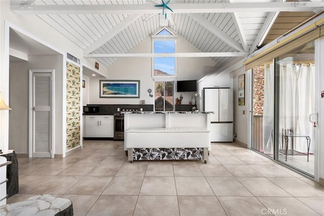 kitchen featuring beamed ceiling, stainless steel electric range oven, fridge, and light tile patterned floors