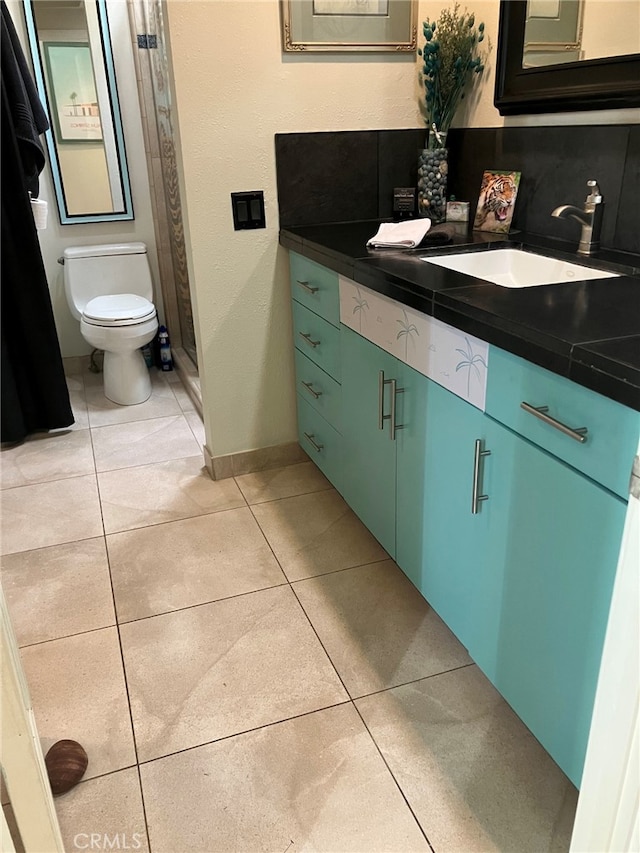 bathroom featuring tile patterned flooring, vanity, and toilet