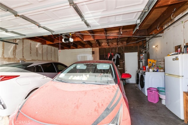 garage featuring water heater, a garage door opener, white fridge, and independent washer and dryer