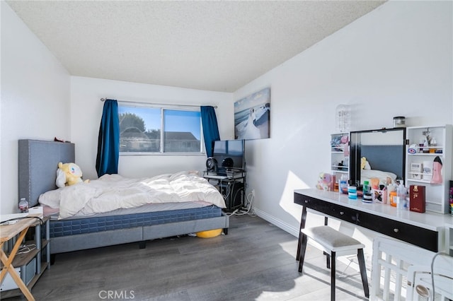 bedroom with a textured ceiling and hardwood / wood-style flooring