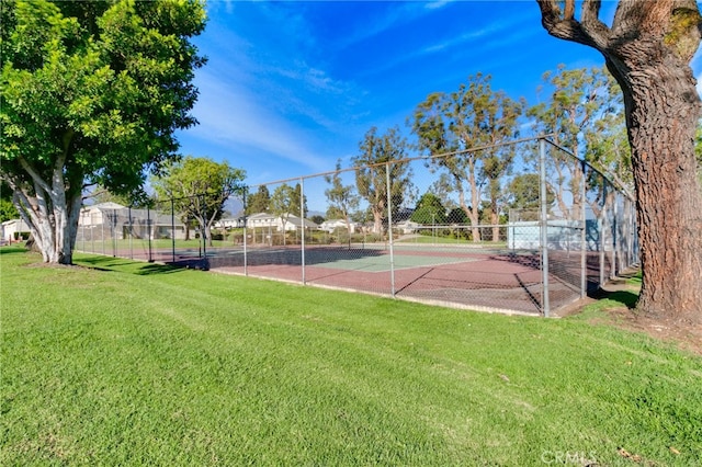 view of sport court with tennis court and a yard