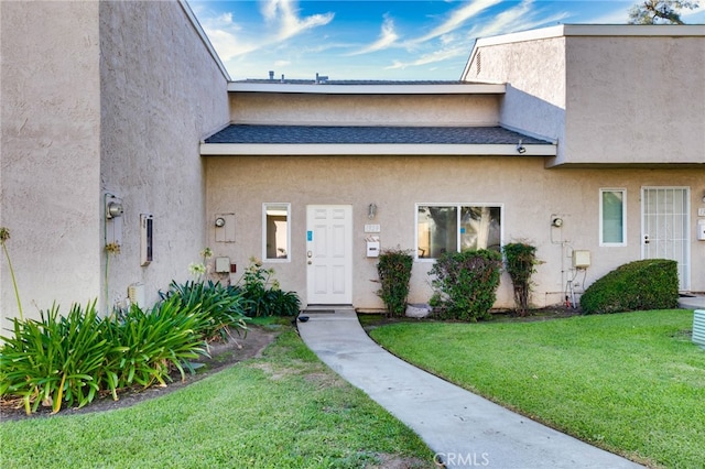 property entrance with a lawn