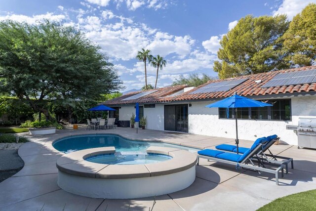 view of swimming pool with a patio and an in ground hot tub