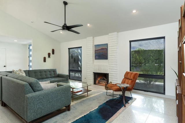 living room featuring ceiling fan, a fireplace, and a towering ceiling