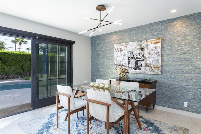 dining area with tile walls, a notable chandelier, and french doors