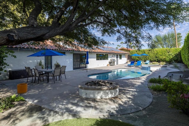 view of pool featuring an outdoor fire pit, a patio, and an in ground hot tub