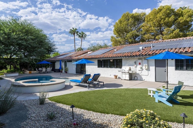 back of property with a pool with hot tub, a yard, solar panels, and a patio