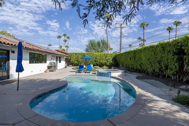 view of swimming pool with an in ground hot tub and a patio