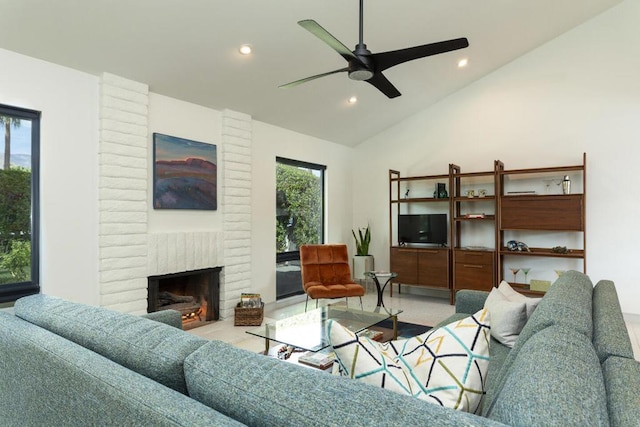 living room featuring vaulted ceiling, ceiling fan, and a fireplace