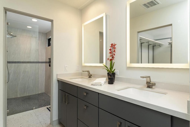 bathroom with vanity and tiled shower