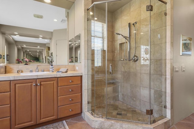 bathroom featuring tile patterned flooring, vanity, and walk in shower