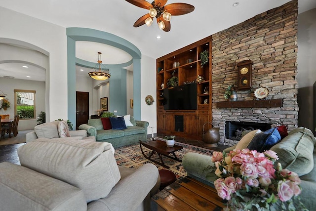 living room with a fireplace, hardwood / wood-style floors, ceiling fan, and built in shelves