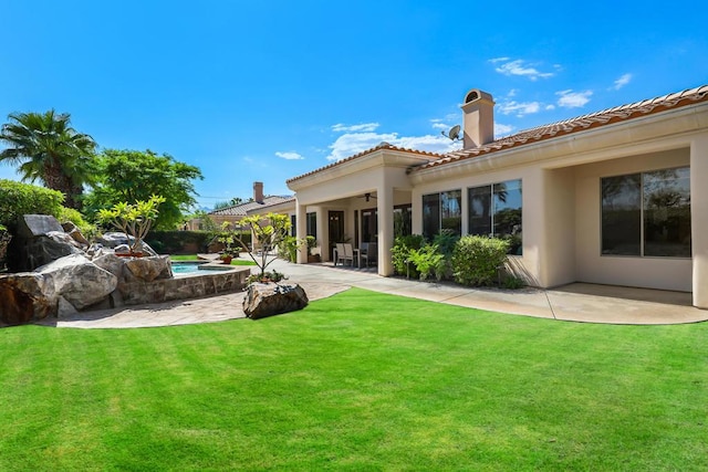 back of property featuring a yard and a patio