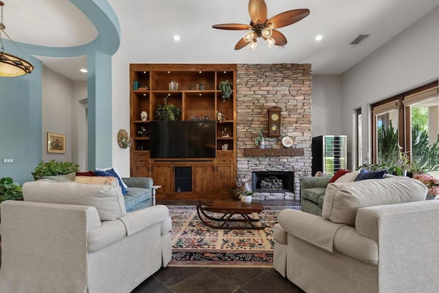 living room featuring ceiling fan and a fireplace