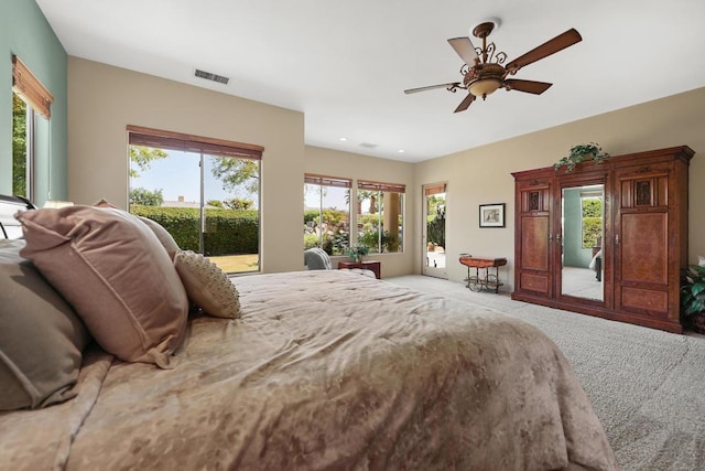 bedroom featuring multiple windows, ceiling fan, and light colored carpet