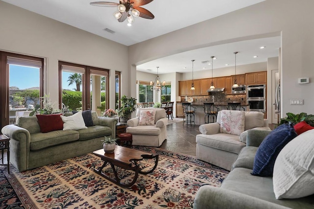 living room with ceiling fan with notable chandelier