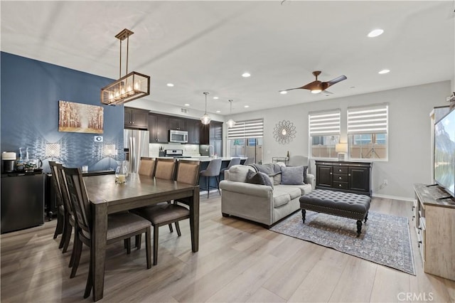 dining area with ceiling fan and light hardwood / wood-style floors