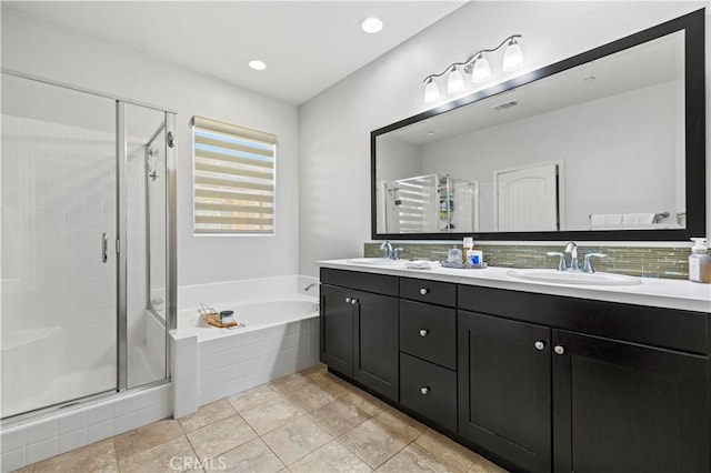 bathroom featuring tile patterned flooring, shower with separate bathtub, and vanity