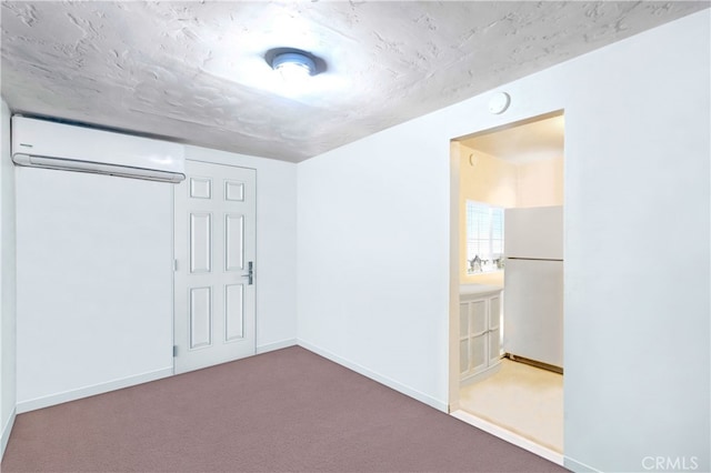 carpeted spare room with a textured ceiling and an AC wall unit