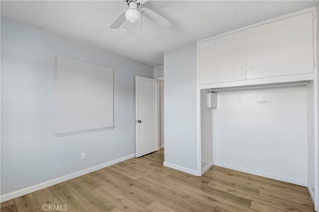 unfurnished bedroom with ceiling fan, a textured ceiling, light hardwood / wood-style flooring, and a closet