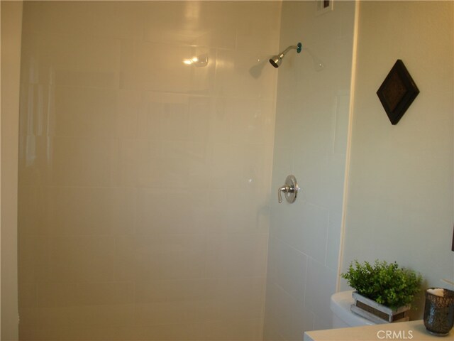 bathroom featuring toilet and tiled shower