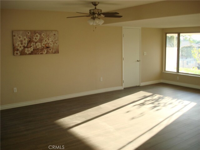 empty room with ceiling fan and dark hardwood / wood-style floors