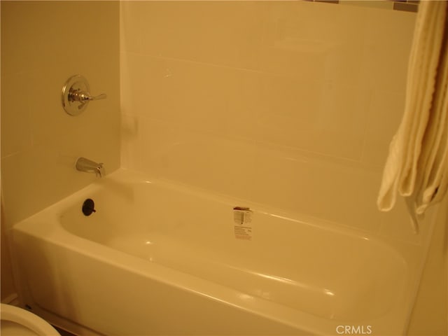 bathroom featuring shower / tub combo and toilet