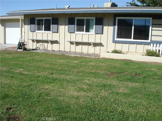 view of side of home featuring a garage and a yard