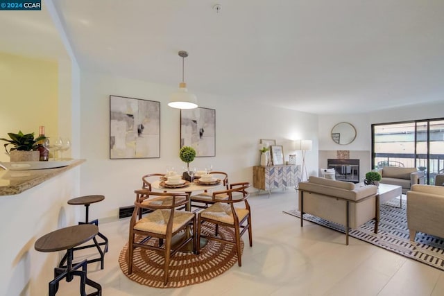 dining space featuring a tiled fireplace