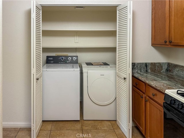 laundry room with washing machine and clothes dryer and light tile patterned flooring